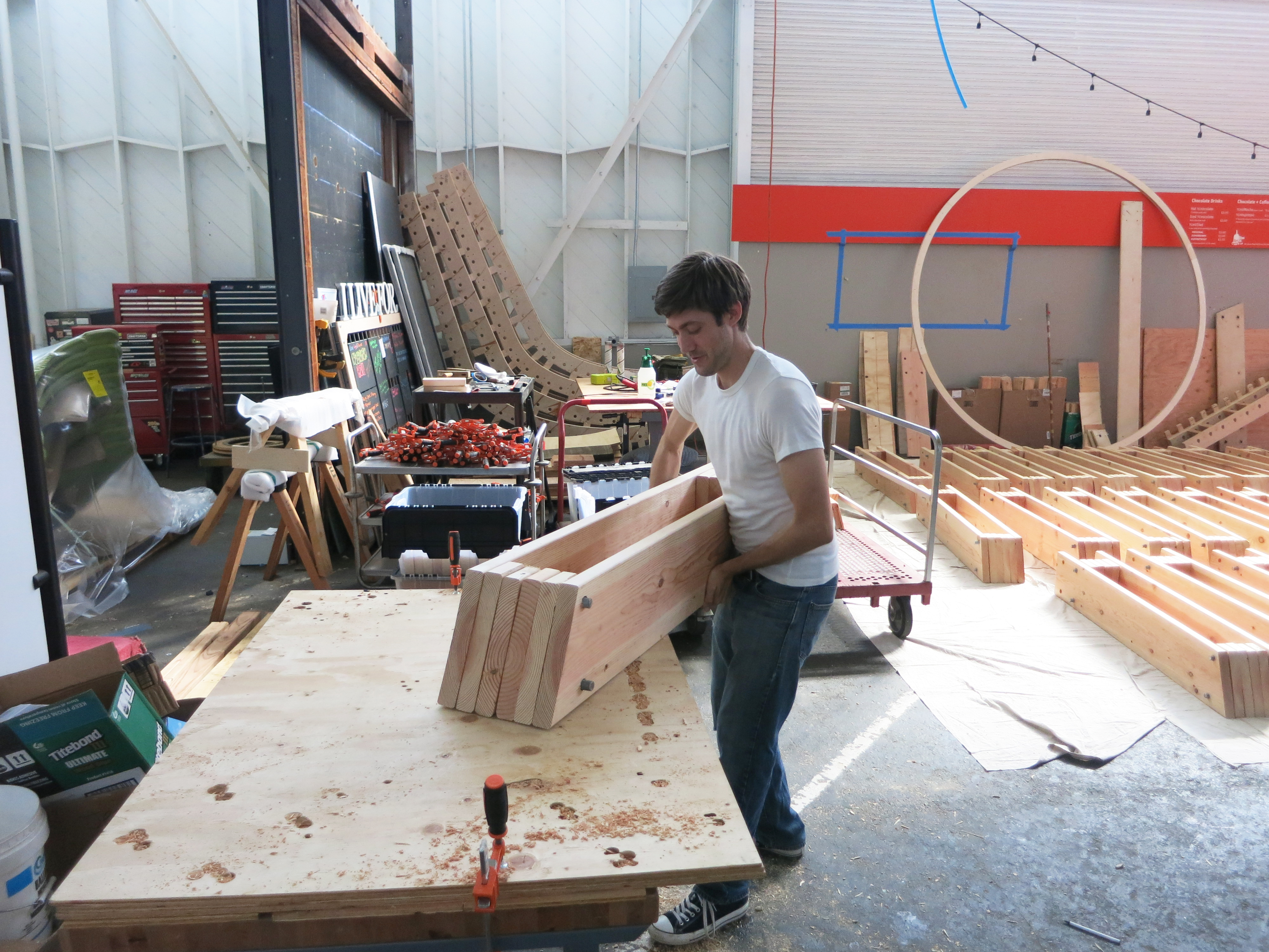 Build team member working on a wooden structure in the fabrication workshop