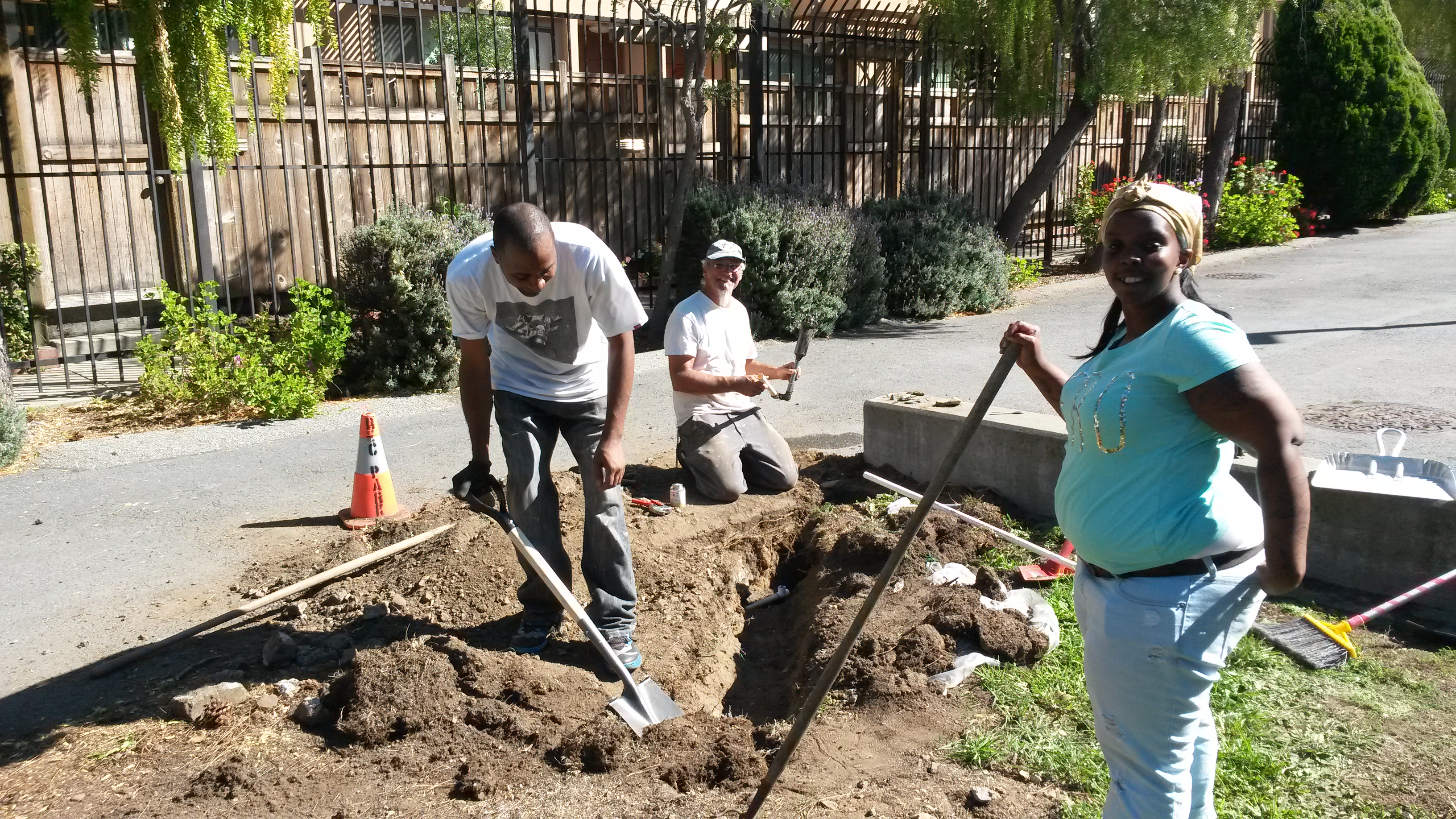 Community members preparing soil for a garden installation beside the park path